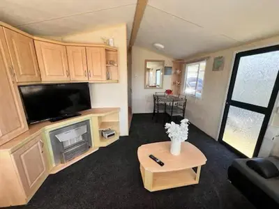 a caravan living room with a tv and a table at Rohannah A and C Ultimate Retreat in Colchester
