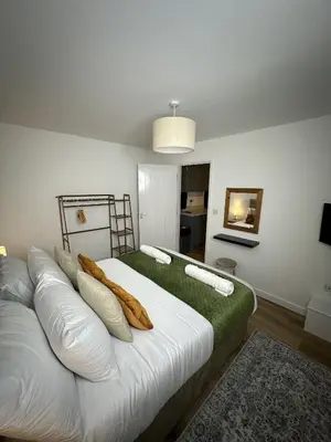 a bedroom with a large white bed with pillows at Rosern Short Stays in St Ives