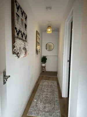 a hallway with white walls and a rug on the floor at Rosern Short Stays in St Ives