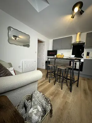a living room with a couch and a kitchen at Rosern Short Stays in St Ives