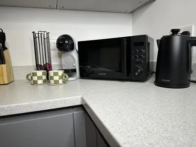 a kitchen counter with a microwave and a coffee maker at Rosern Short Stays in St Ives