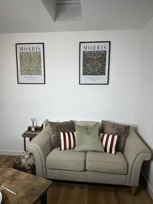 a couch in a living room with two pictures on the wall at Rosern Short Stays in St Ives