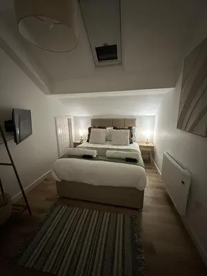 a bedroom with a bed and a rug at Rosern Short Stays in St Ives