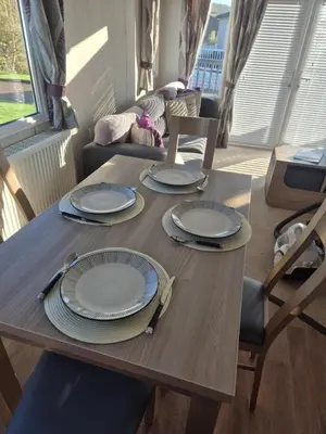 a dining room table with plates and utensils on it at Lovely Caravan With Front Decking At Carlton Meres Park Ref 60018R in Saxmundham