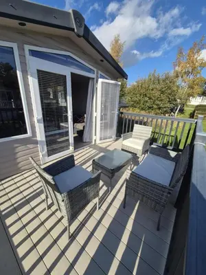 a deck with two chairs and a table and chairs at Lovely Caravan With Front Decking At Carlton Meres Park Ref 60018R in Saxmundham