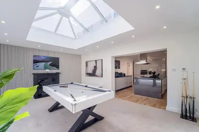 a pool table in a living room with a skylight at Emerson Park Villa, Heated Pool, Hot Tub, Cinema in Harold Wood