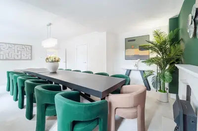a dining room with a table and green chairs at Emerson Park Villa, Heated Pool, Hot Tub, Cinema in Harold Wood