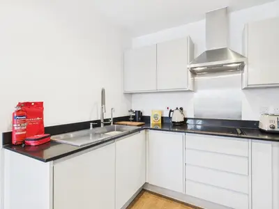 a white kitchen with white cabinets and a sink at Mid-Long Stay 1 Bedroom Apartment Great Baddow in Great Baddow