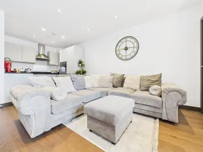 a living room with a couch and a clock on the wall at Mid-Long Stay 1 Bedroom Apartment Great Baddow in Great Baddow