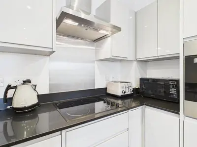a kitchen with white cabinets and a blender on the counter at Mid-Long Stay 1 Bedroom Apartment Great Baddow in Great Baddow