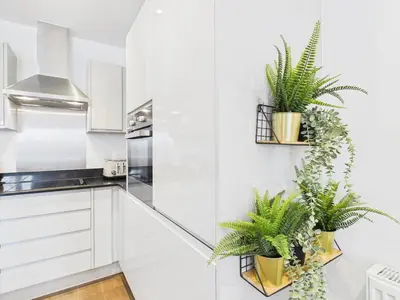 a kitchen with white cabinets and potted plants at Mid-Long Stay 1 Bedroom Apartment Great Baddow in Great Baddow