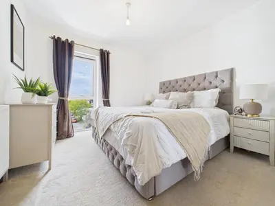 a white bedroom with a large bed and a window at Mid-Long Stay 1 Bedroom Apartment Great Baddow in Great Baddow