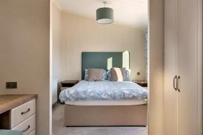 a bedroom with a bed with a large mirror at Finest Retreats - Pembroke Luxury Lodge