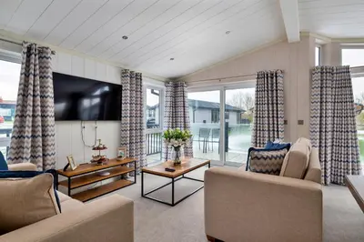 a living room with a couch and a tv at Finest Retreats - Churchill Luxury Lodge