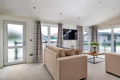 a living room with a couch and a tv at Finest Retreats - Churchill Luxury Lodge