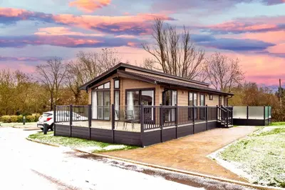 a small house with a balcony on a parking lot at Finest Retreats - Churchill Luxury Lodge