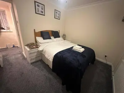 a bedroom with a bed with two towels on it at 4 Bed House - Sleeps 8 - Pets - Parking - Wifi in Great Clacton