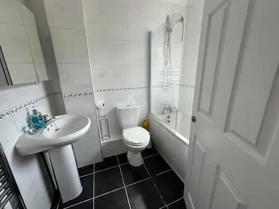 a white bathroom with a toilet and a sink at 4 Bed House - Sleeps 8 - Pets - Parking - Wifi in Great Clacton