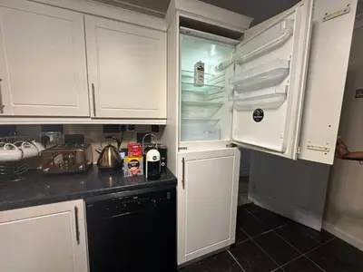 a kitchen with an empty refrigerator with its door open at 4 Bed House - Sleeps 8 - Pets - Parking - Wifi in Great Clacton