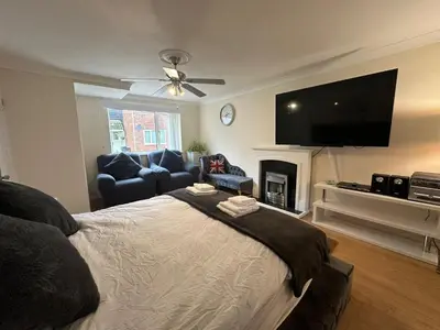 a bedroom with a bed and a tv and a couch at 4 Bed House - Sleeps 8 - Pets - Parking - Wifi in Great Clacton