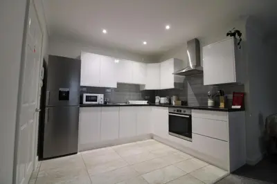 a kitchen with white cabinets and a refrigerator at Colchester Roof Top Flat - Central, Business, Travel in Colchester