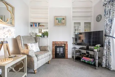 a living room with a couch and a television at Quayside Cottage in Waldringfield
