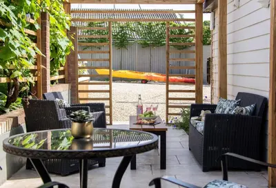 a patio with a table and chairs and a playground at The Boathouse in Waldringfield