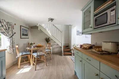 a kitchen with a table and a dining room at The Boathouse in Waldringfield