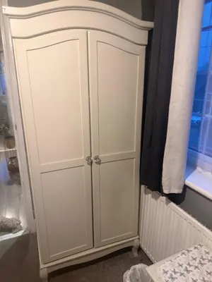 a white cabinet in a bedroom next to a window at Single room in Canvey island in Hadleigh