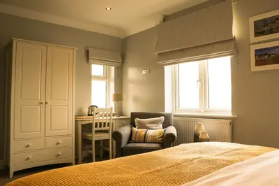 a bedroom with a bed and a chair and a desk at The Victory at Mersea in West Mersea