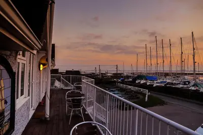 a balcony with a view of a marina with boats at The Victory at Mersea in West Mersea