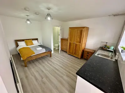 a small room with a bed and a kitchen at Detached, 5 Double Bedrooms, 3 En-Suites, 5 Car Parking in Lexden