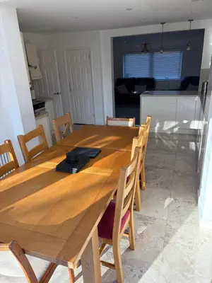 a wooden dining room table with chairs and a kitchen at Detached, 5 Double Bedrooms, 3 En-Suites, 5 Car Parking in Lexden