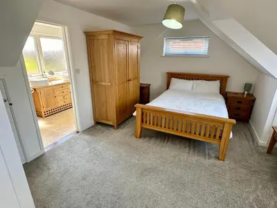a bedroom with a wooden bed and a wooden cabinet at Detached, 5 Double Bedrooms, 3 En-Suites, 5 Car Parking in Lexden