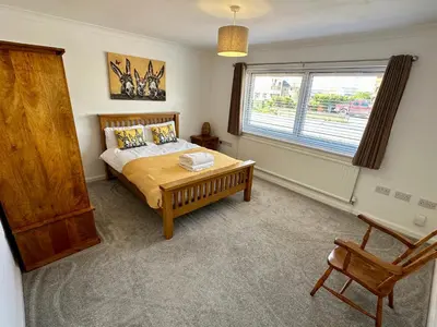 a bedroom with a bed and a window and a chair at Detached, 5 Double Bedrooms, 3 En-Suites, 5 Car Parking in Lexden