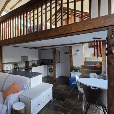 a living room with a couch and a table at The Old Stables in Felixstowe