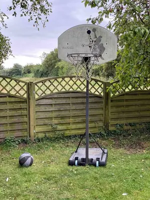 a basketball hoop in front of a fence at Family Country Home in Stoke Ferry