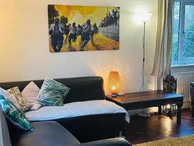 a living room with a couch and a painting on the wall at Family Country Home in Stoke Ferry
