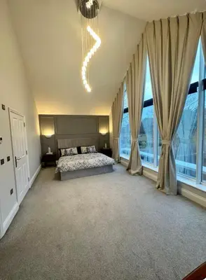 a bedroom with a bed and large windows at Haggard House Stock in Stock