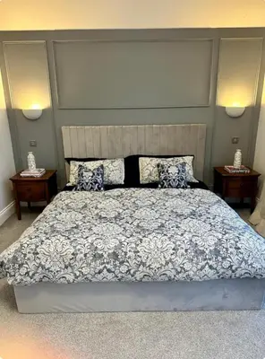 a bedroom with a large bed and two night stands at Haggard House Stock in Stock
