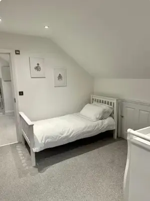 a white bedroom with a bed in the corner at Haggard House Stock in Stock