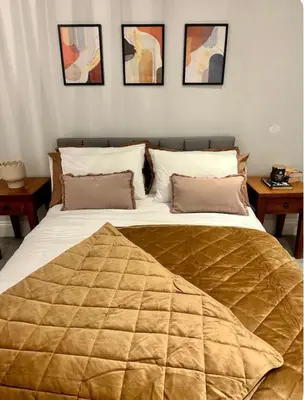 a large bed with a blanket on it in a bedroom at Haggard House Stock in Stock