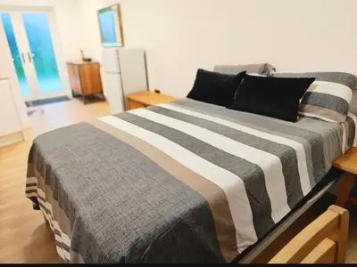 a bedroom with a bed with a striped blanket at 1 Bed LuxuryHouse- Sleeps 2- Garden Wifi Parking in Hornchurch