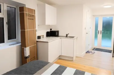 a kitchen with white cabinets and a microwave at 1 Bed LuxuryHouse- Sleeps 2- Garden Wifi Parking in Hornchurch