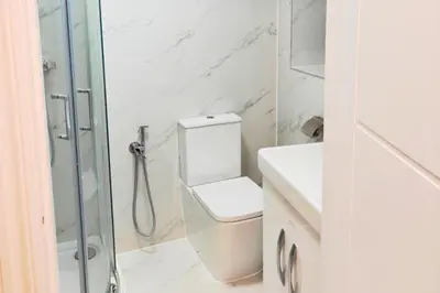 a white bathroom with a toilet and a shower at 1 Bed LuxuryHouse- Sleeps 2- Garden Wifi Parking in Hornchurch