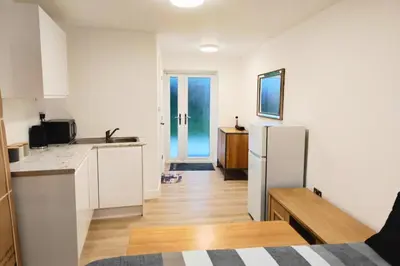 a kitchen with white cabinets and a refrigerator at 1 Bed LuxuryHouse- Sleeps 2- Garden Wifi Parking in Hornchurch