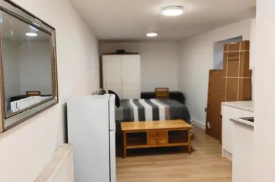 a small room with a refrigerator and a table at 1 Bed LuxuryHouse- Sleeps 2- Garden Wifi Parking in Hornchurch
