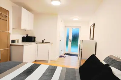a white kitchen with a refrigerator in a room at 1 Bed LuxuryHouse- Sleeps 2- Garden Wifi Parking in Hornchurch