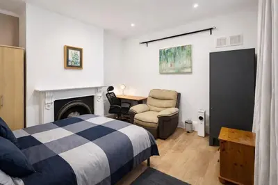 a bedroom with a bed and a chair and a desk at landvue stays, The Colchester town White House 4 bed 2 bath! in Mundon