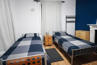 two beds in a bedroom with blue and white at landvue stays, The Colchester town White House 4 bed 2 bath! in Mundon